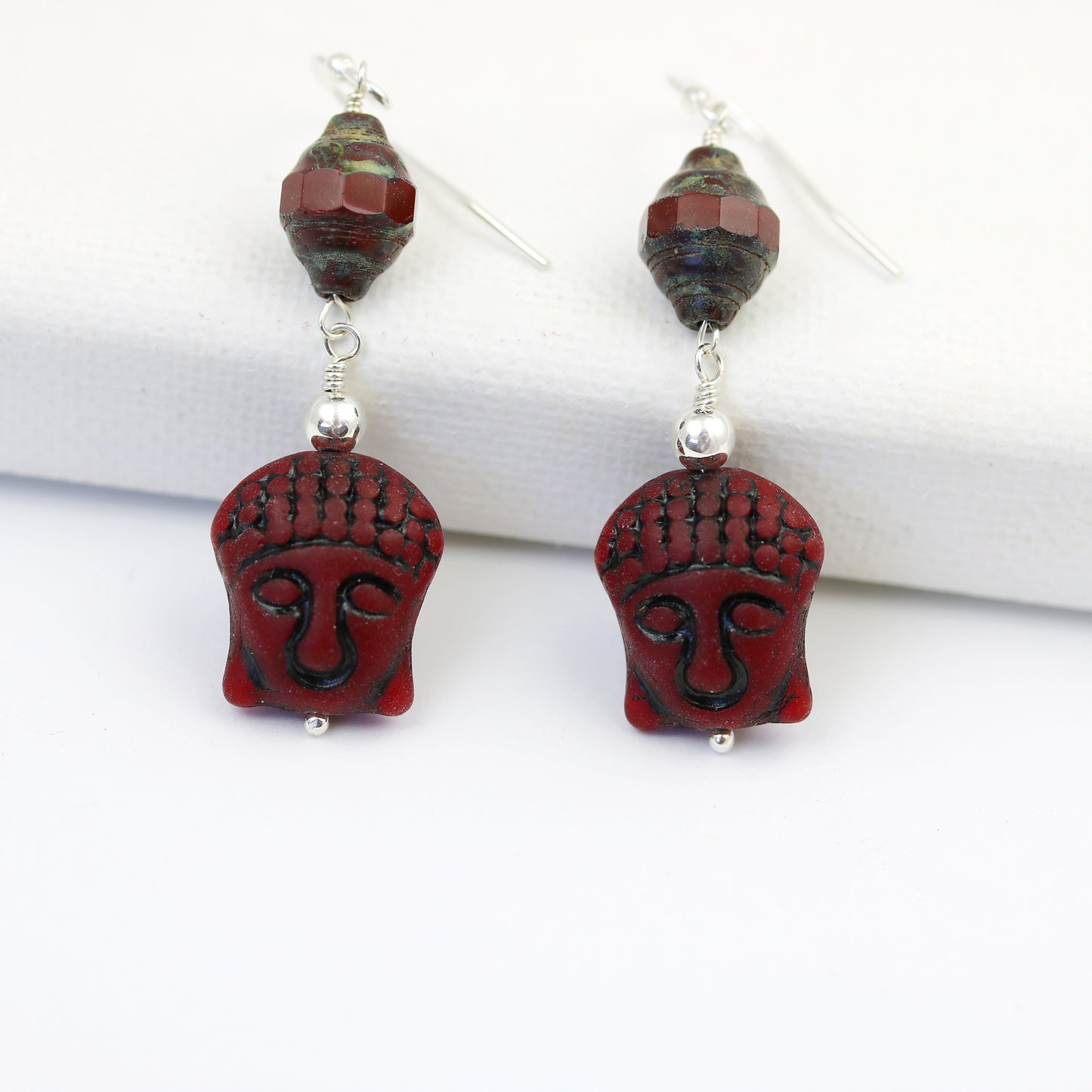 close up picture of buddha earrings with sterling silver accent round beads and Picasso turbine shaped bead