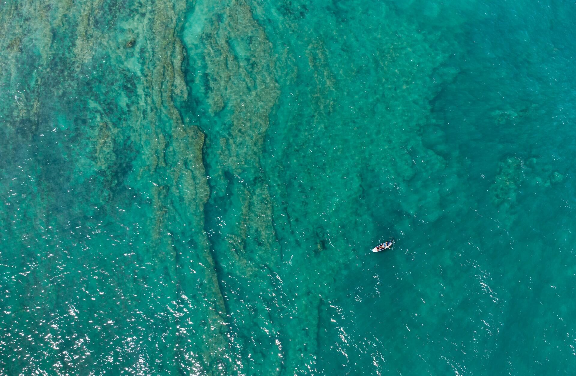 Overhead view of ocean with small boat