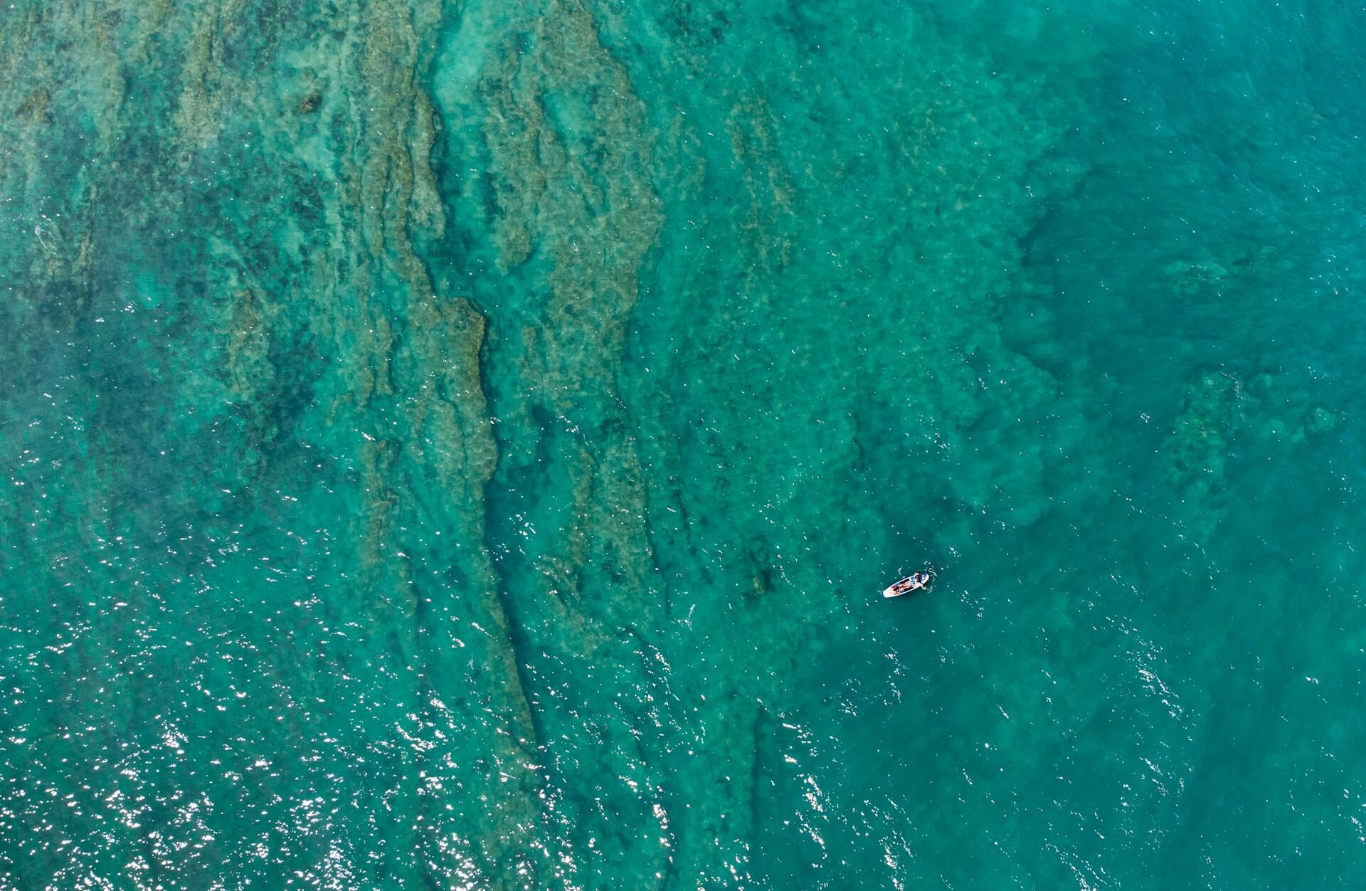 Overhead view of ocean with small boat