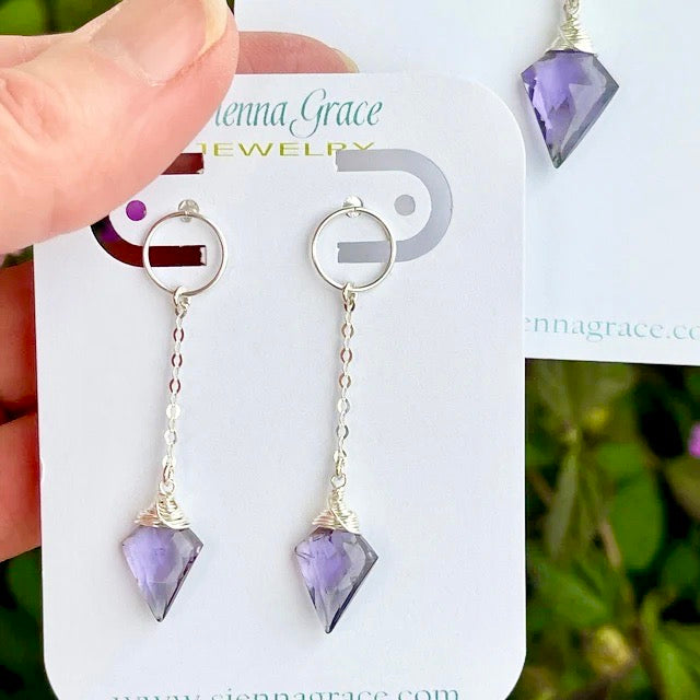 Arrowhead Amethyst Earrings on a card being held up for the camera